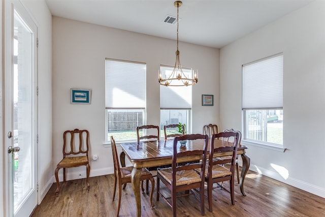 dining area featuring hardwood / wood-style flooring, plenty of natural light, and a notable chandelier