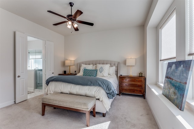 bedroom with light carpet, ensuite bath, and ceiling fan