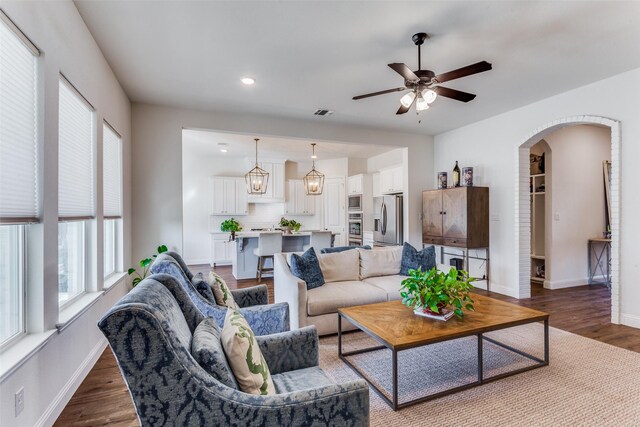 living room with ceiling fan and dark wood-type flooring