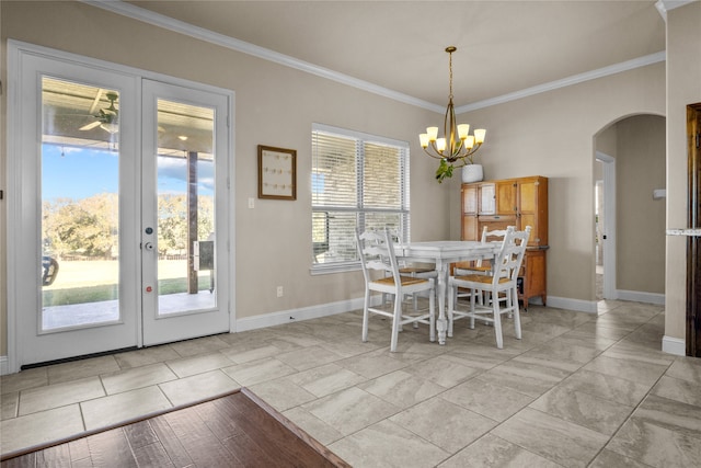 unfurnished dining area featuring a notable chandelier, crown molding, and french doors