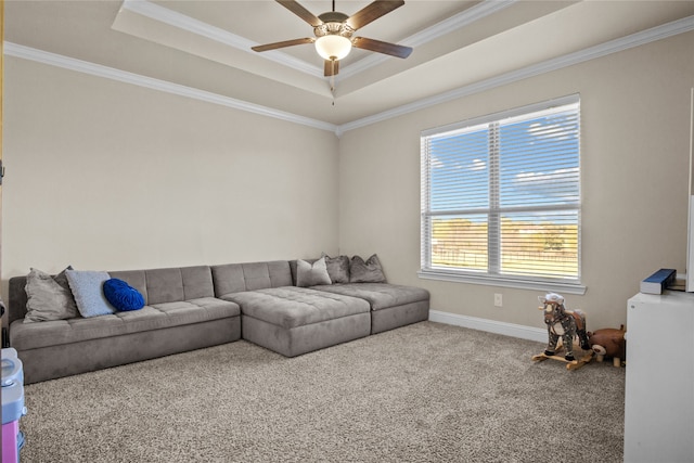 carpeted living room with ceiling fan, a raised ceiling, and crown molding