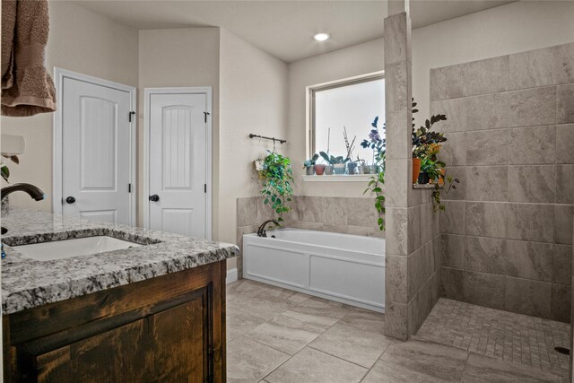 bathroom with vanity and independent shower and bath