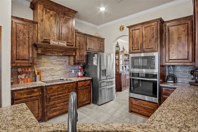 kitchen featuring light stone countertops, crown molding, appliances with stainless steel finishes, and tasteful backsplash