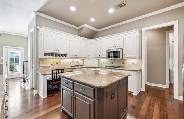 kitchen featuring white cabinets, dark hardwood / wood-style floors, a center island, and stainless steel appliances