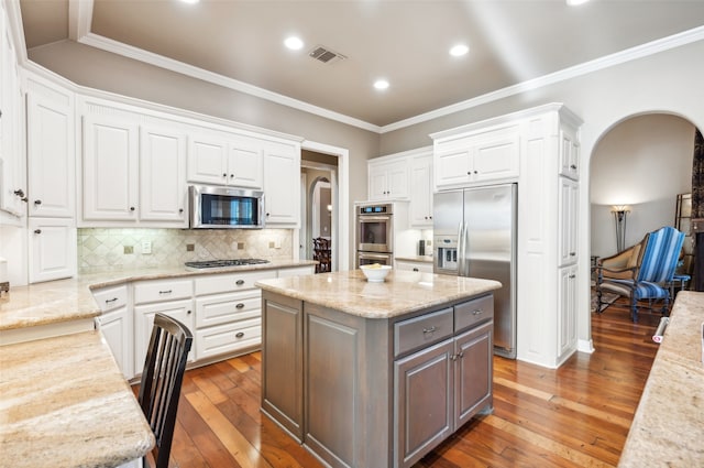 kitchen with white cabinets, a center island, dark hardwood / wood-style flooring, and stainless steel appliances