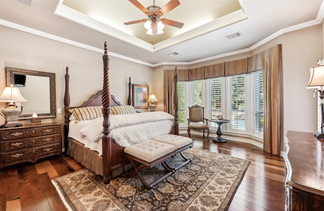 bedroom with dark hardwood / wood-style flooring, a raised ceiling, ceiling fan, and crown molding