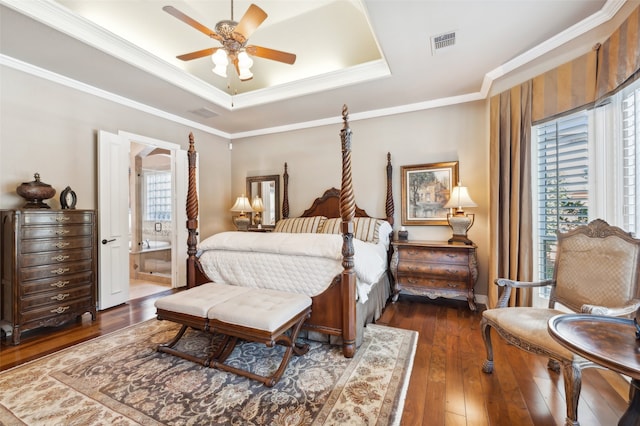 bedroom featuring ornamental molding, a raised ceiling, ceiling fan, dark wood-type flooring, and connected bathroom