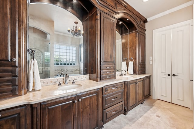 bathroom featuring tile patterned floors, ornamental molding, a washtub, vanity, and an inviting chandelier