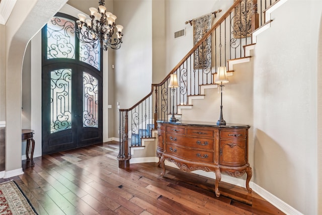 entrance foyer featuring dark hardwood / wood-style floors, an inviting chandelier, a high ceiling, and french doors