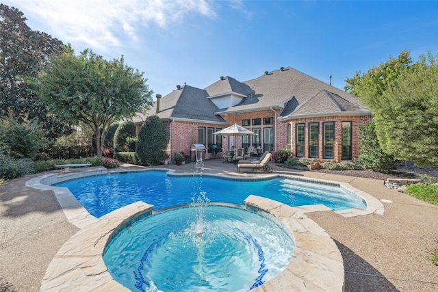 view of pool with grilling area, an in ground hot tub, and a patio