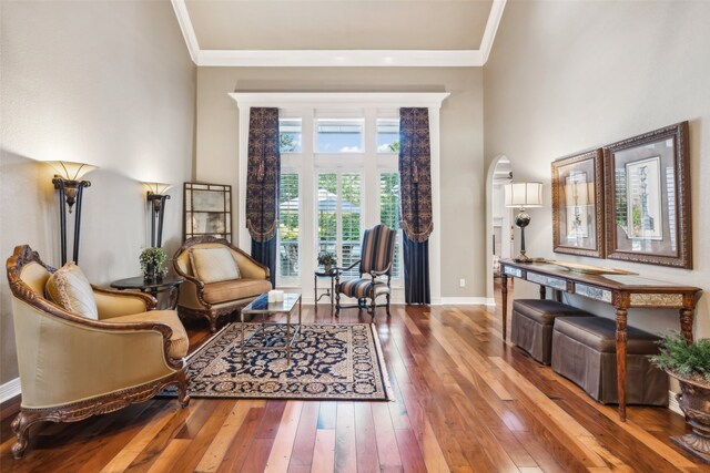 living area with hardwood / wood-style floors and ornamental molding