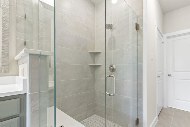 full bath with vanity, tile patterned flooring, and a stall shower
