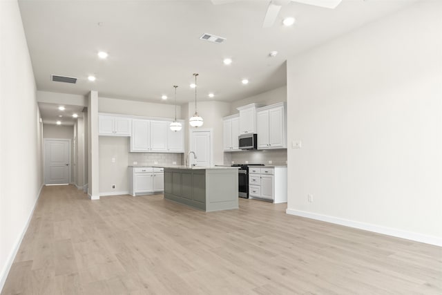 kitchen featuring light wood finished floors, visible vents, a sink, and appliances with stainless steel finishes