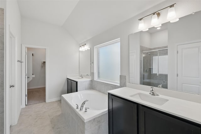 bathroom with a garden tub, two vanities, a stall shower, a sink, and vaulted ceiling