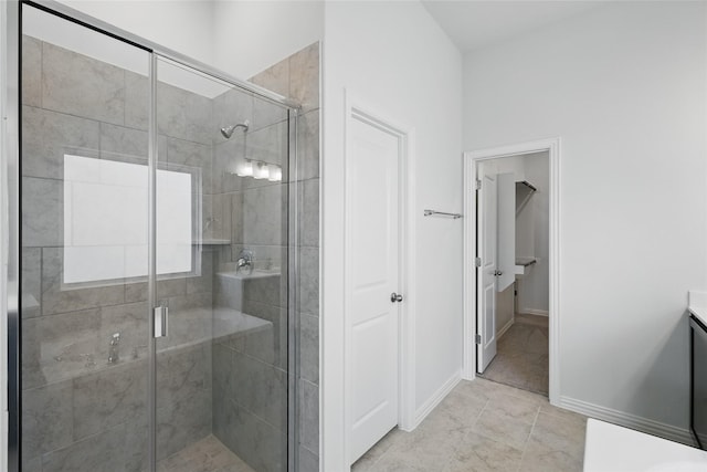 bathroom featuring a stall shower, vanity, and baseboards