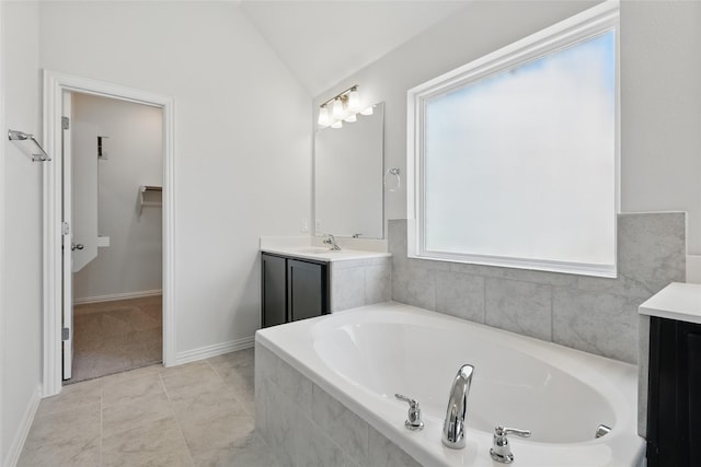 bathroom with vanity, baseboards, lofted ceiling, a spacious closet, and a bath