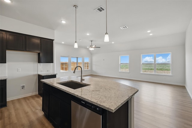 kitchen featuring a sink, visible vents, light stone counters, and dishwasher