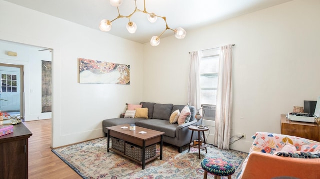 living room with light hardwood / wood-style floors and an inviting chandelier