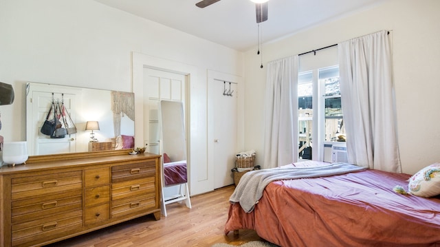 bedroom with ceiling fan, cooling unit, and light hardwood / wood-style flooring