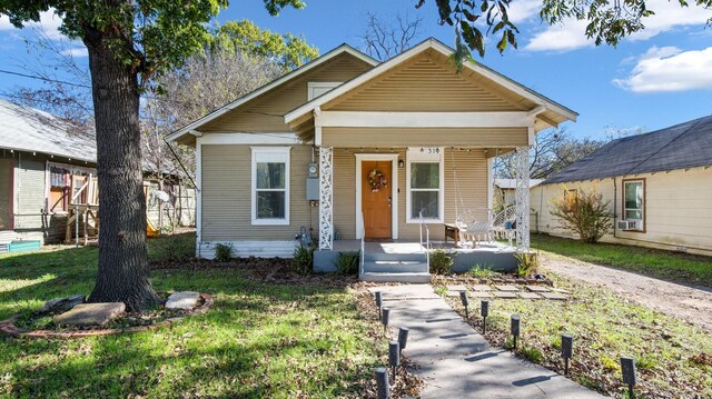 bungalow-style home with a porch and a front lawn