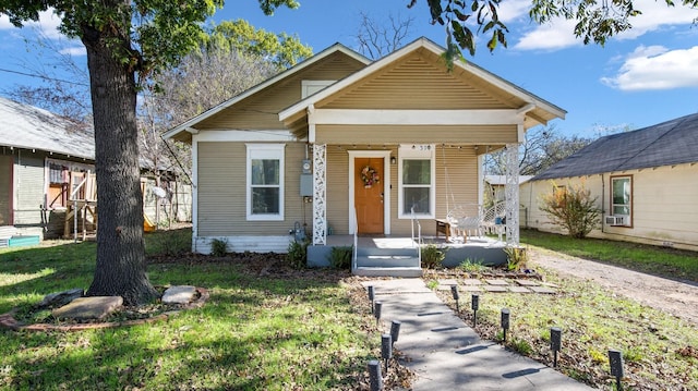 bungalow-style home featuring a front lawn and covered porch