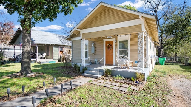 bungalow-style home with covered porch and a front lawn