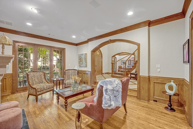 sitting room featuring light wood-type flooring, crown molding, and french doors