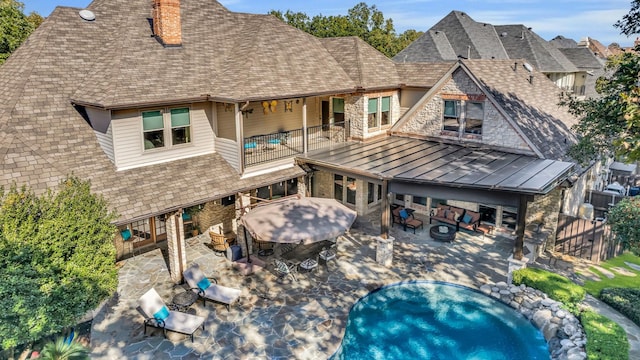 rear view of property with a balcony and a patio