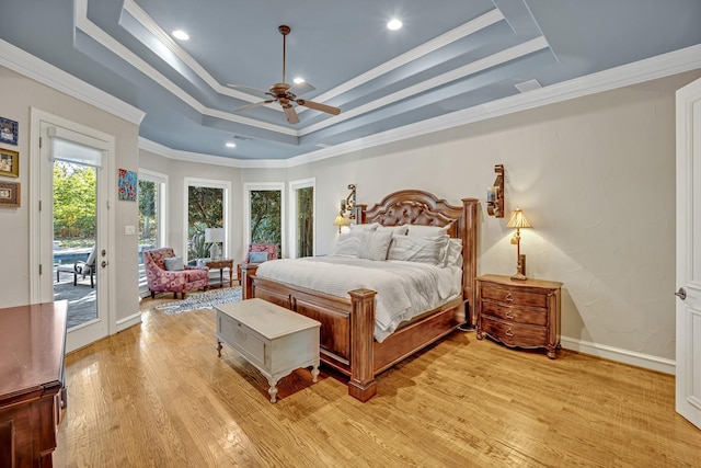 bedroom featuring light hardwood / wood-style floors, a raised ceiling, access to outside, ceiling fan, and crown molding