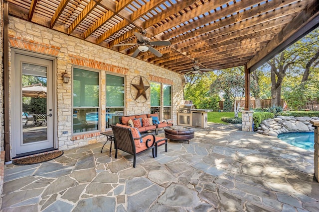 view of patio with ceiling fan, an outdoor kitchen, and an outdoor living space