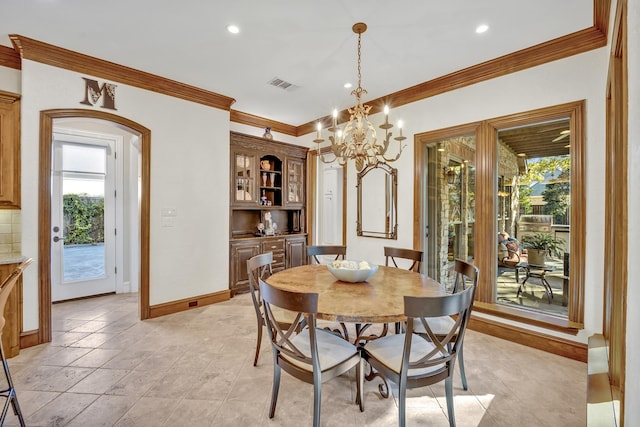 dining area with ornamental molding and a chandelier