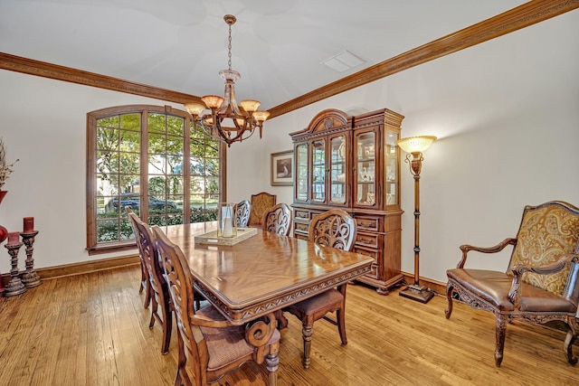 dining room featuring ornamental molding, light hardwood / wood-style floors, and a chandelier