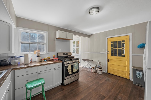 kitchen with white cabinets, dark hardwood / wood-style flooring, plenty of natural light, and stainless steel range with gas stovetop