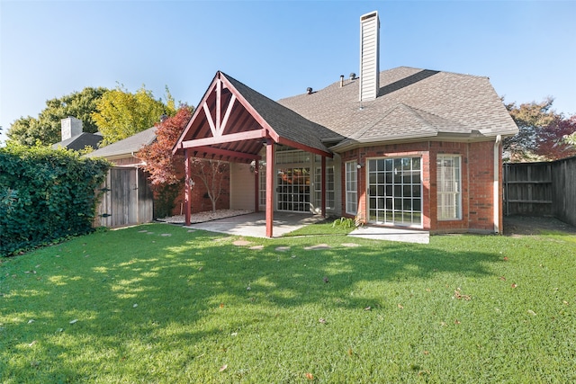 back of house with a patio area and a yard