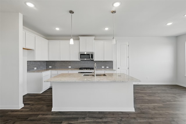 5036 Water Lily Ln, Fort Worth, TX 76036 - kitchen with a kitchen island with sink, a sink, stainless steel microwave, light stone counters, and dark wood-style flooring