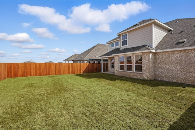 5036 Water Lily Ln, Fort Worth, TX 76036 - rear view of property featuring brick siding, a lawn, a shingled roof, and a fenced backyard