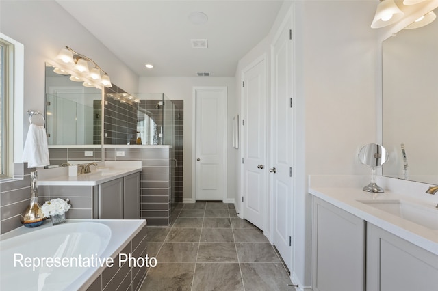 bathroom with tile patterned floors, vanity, and independent shower and bath