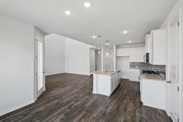 5036 Water Lily Ln, Fort Worth, TX 76036 - kitchen with dark wood-type flooring, a sink, stainless steel microwave, open floor plan, and white cabinets