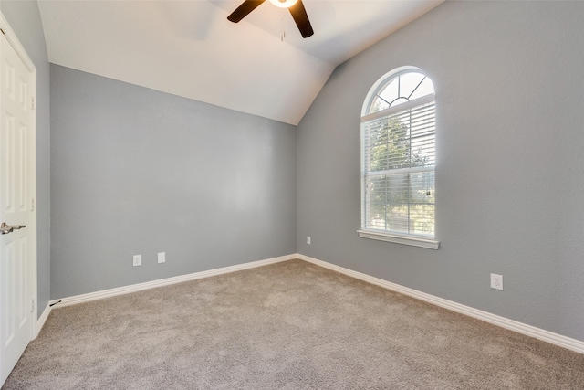 carpeted spare room with ceiling fan and lofted ceiling