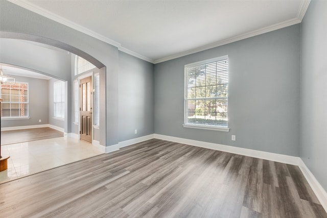 unfurnished room with wood-type flooring, a notable chandelier, and ornamental molding