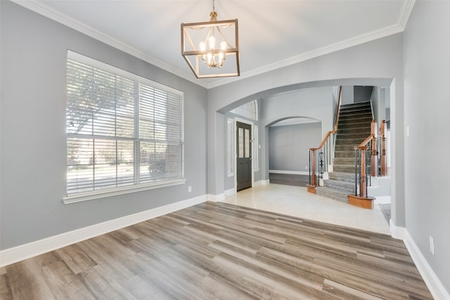 interior space with a chandelier, wood-type flooring, and ornamental molding