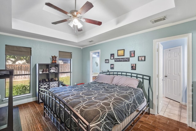 bedroom with crown molding, ceiling fan, and a tray ceiling