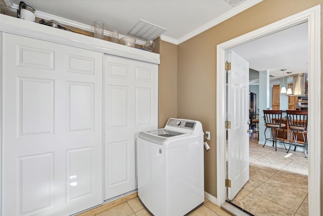 laundry room with crown molding, washer / dryer, and light tile patterned floors