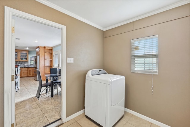 laundry room featuring ornamental molding, washer / clothes dryer, and light tile patterned floors