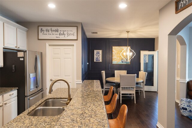 kitchen featuring backsplash, a center island with sink, a kitchen breakfast bar, sink, and stainless steel appliances