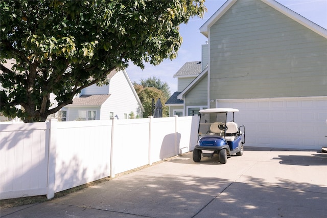 view of home's exterior with driveway, a garage, and fence