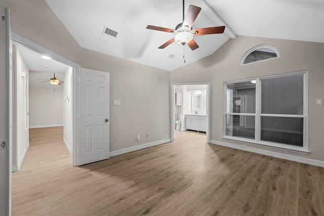 unfurnished room featuring ceiling fan, lofted ceiling with beams, and light wood-type flooring