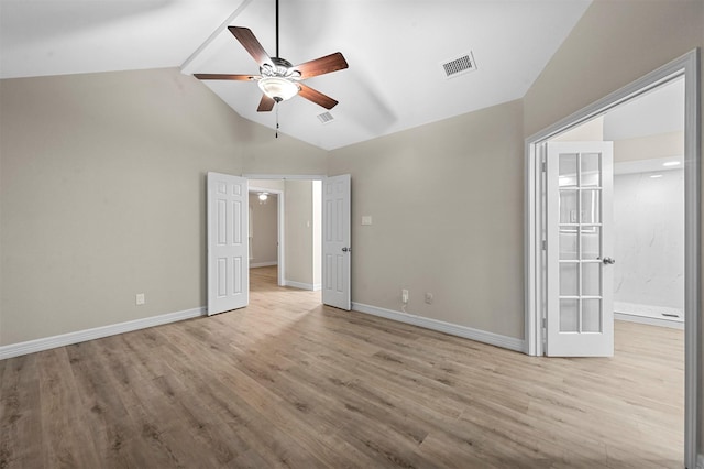 unfurnished bedroom featuring ceiling fan, french doors, light hardwood / wood-style floors, and vaulted ceiling