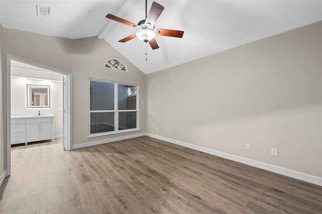 unfurnished bedroom with connected bathroom, ceiling fan, beamed ceiling, high vaulted ceiling, and light wood-type flooring