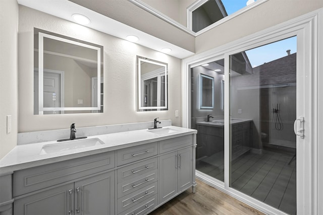 bathroom with hardwood / wood-style floors, vanity, and walk in shower